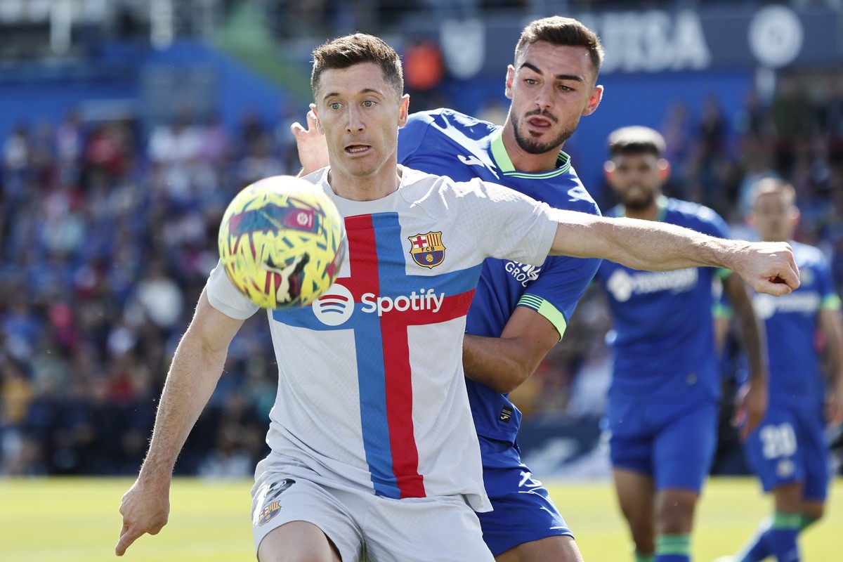 epa10575695 Getafe's defender Juan Iglesias (R) in action against FC Barcelona's striker Robert Lewandowski (L) during the Spanish LaLiga soccer match between Getafe CF and FC Barcelona, in  ...