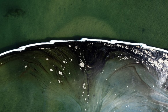 An aerial photo shows floating barriers known as booms set up to try to stop further incursion into the Wetlands Talbert Marsh after an oil spill in Huntington Beach, Calif., on Huntington Beach, Cali ...