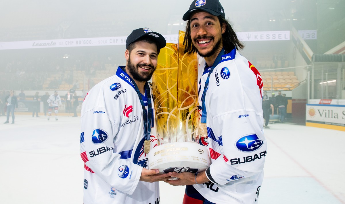 Zurich's player Inti Pestoni, left and Zurich's player Samuel Guerra, right, hold up the trophy after winning the Swiss championship title, during the seventh match of the playoff final of t ...