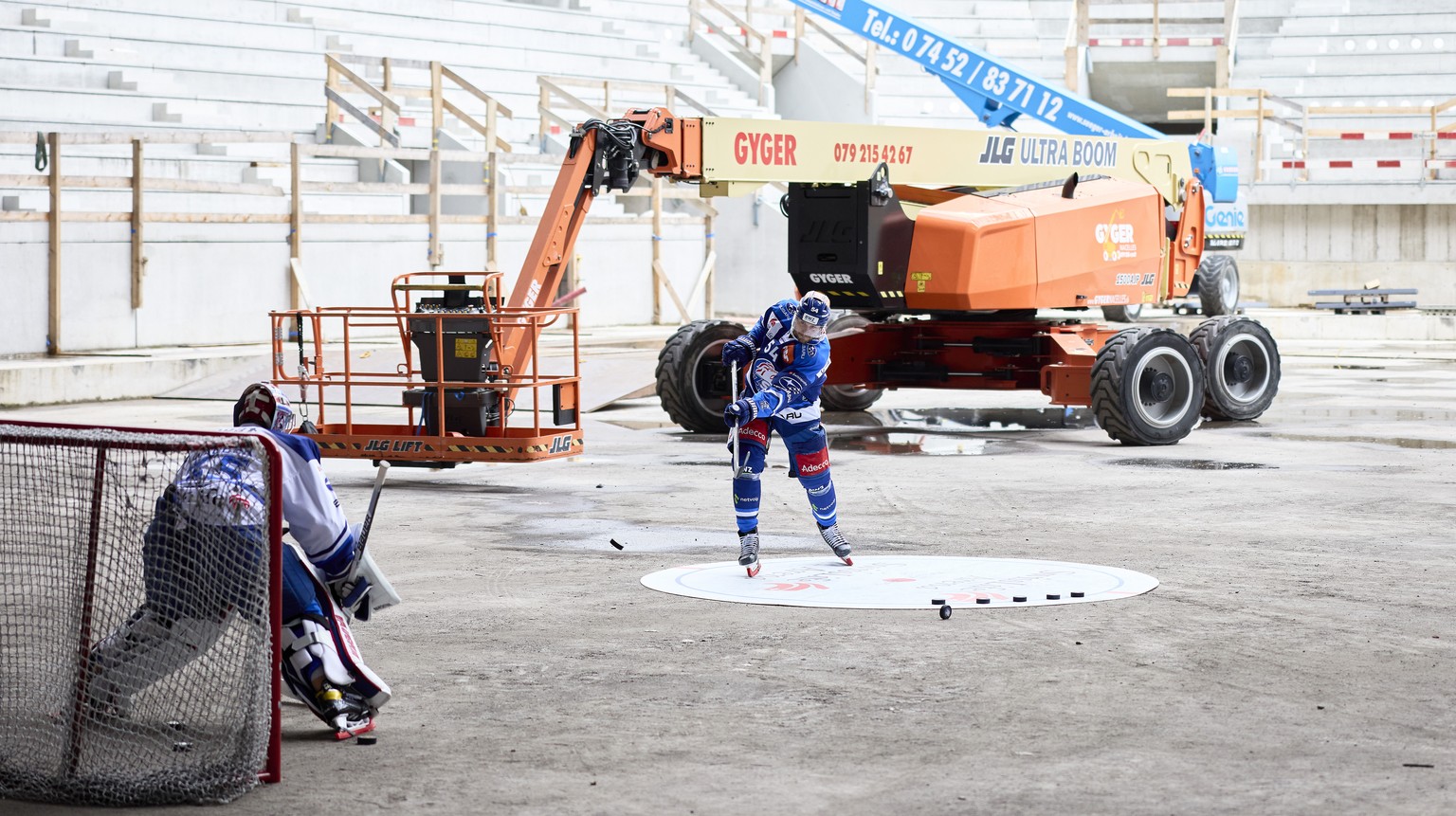 Die beiden ZSC Lions Spieler Ludovic Waeber, links, und Christian Marti machen den ersten Torschuss im neuen Stadion, waehrend einer Baustellenfuehrung in der Swiss Life Arena, am Sonntag, 29. August  ...