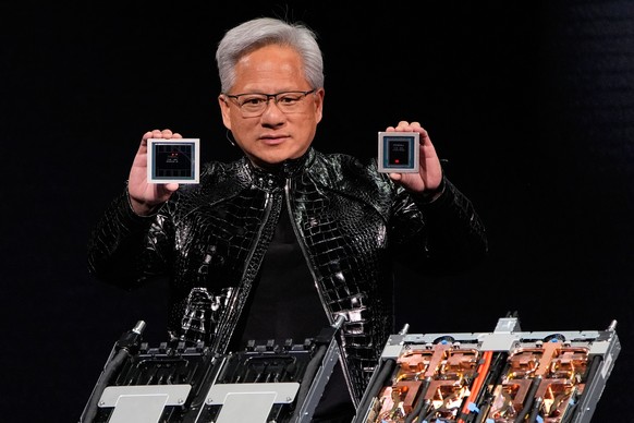 Nvidia founder and CEO Jensen Huang holds up a Rubin GPU and a Vera CPU as he speaks during a Nvidia news conference ahead of the CES tech show Monday, Jan. 5, 2026, in Las Vegas. (AP Photo/John Loche ...