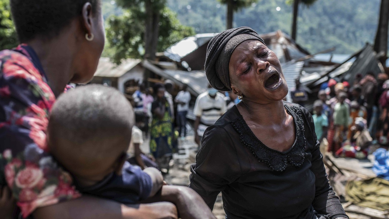 A woman reacts upon discovering that members of her family were killed, as volunteers nearby remove their bodies, in the village of Nyamukubi, South Kivu province, in Congo Saturday, May 6, 2023. The  ...
