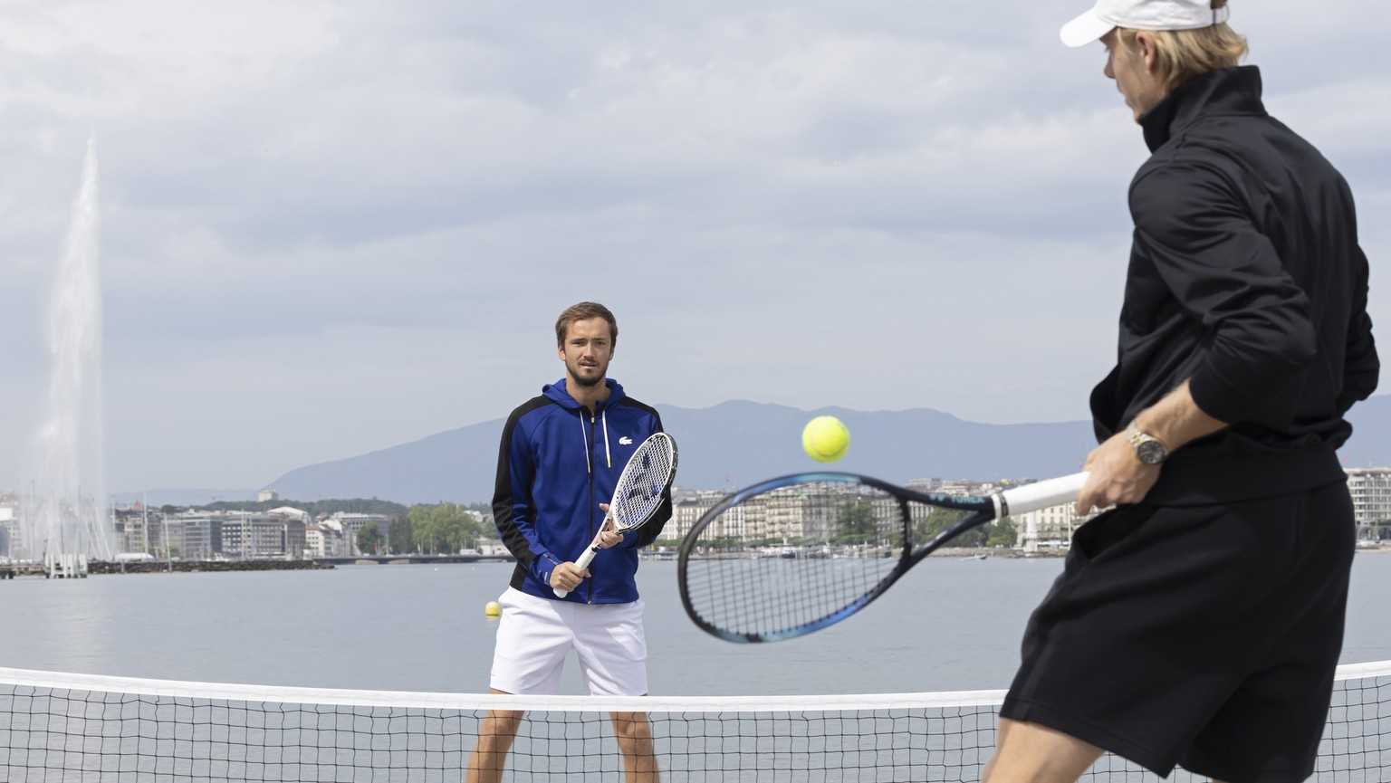 Daniil Medvedev, left, of Russia, and Denis Shapovalov, right, of Canada, play tennis in the plage des Eaux-Vives with the famous water fountain &quot;Le Jet d&#039;Eau&quot; seen in the background du ...