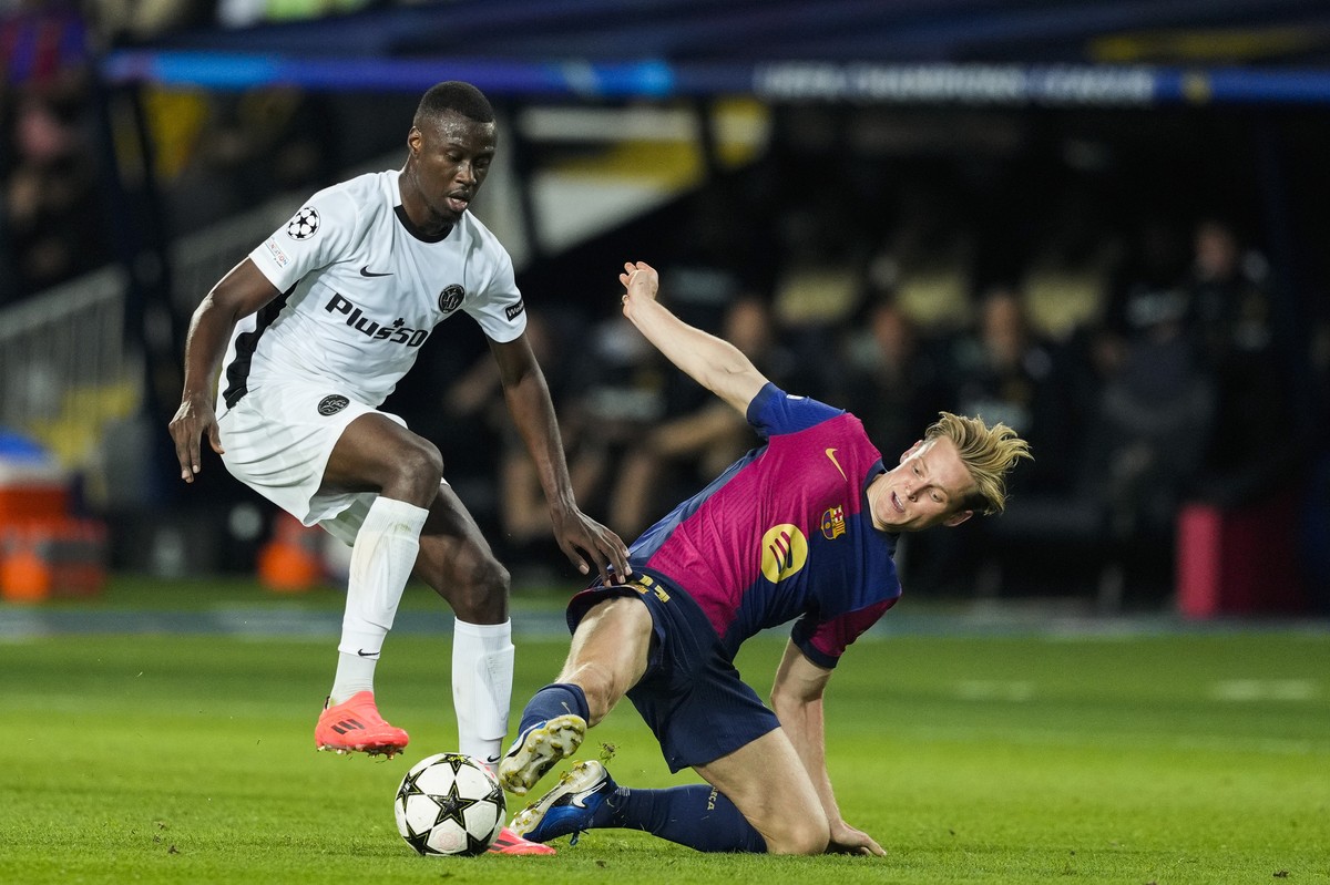 epa11636726 FC Barcelona's Frenkie De Jong (R) in action against Young Boys' Cheikh Niasse (L) during the UEFA Champions League soccer match between FC Barcelona and BSC Young Boys, in Barce ...