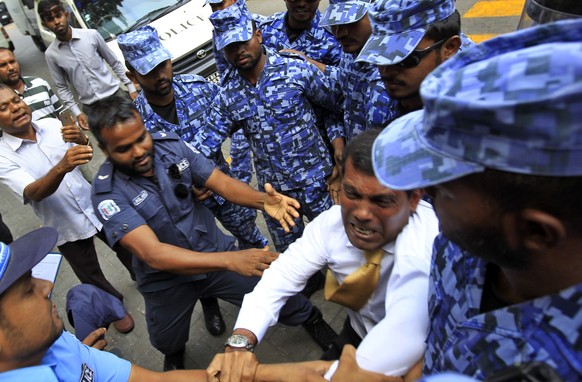 Der ehemalige Präsident (goldene Krawatte, weisses Hemd) Mohamed Nasheed wird von Polizeikräften daran gehindert, mit Journalisten zu sprechen.