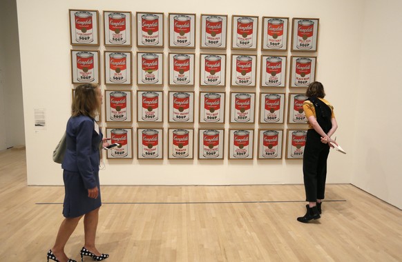 FILE- A pair of women look at the 1962 pop piece called &quot;Campbell&#039;s Soup Cans&quot; at the exhibition, &quot;Andy Warhol _ From A to B and Back Again, in San Francisco on May 15, 2019. Clima ...