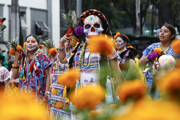 epa12498274 People wearing catrina makeup and traditional clothing walk during the Day of the Dead parade in Mexico City, Mexico, 01 November 2025. EPA/SASHENKA GUTIERREZ