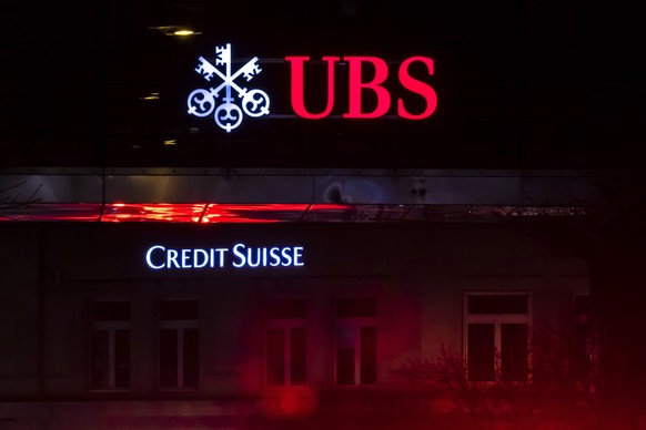epa10529302 The illuminated logos of the Swiss banks Credit Suisse and UBS are displayed on buildings in Zurich, Switzerland, 18 March 2023. Shares of Credit Suisse lost more than one-quarter of their ...