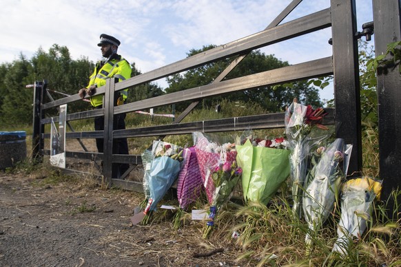 Flower tributes at an entrance to Fryent Country Park, in north London, where a murder investigation has been launched following deaths of two sisters, Monday June 8, 2020. Police are treating the dea ...