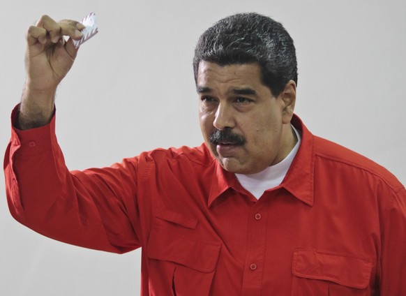 In this photo released by Miraflores Press Office, Venezuela&#039;s President Nicolas Maduro shows his ballot after casting a vote for a constitutional assembly in Caracas, Venezuela on Sunday, July 3 ...