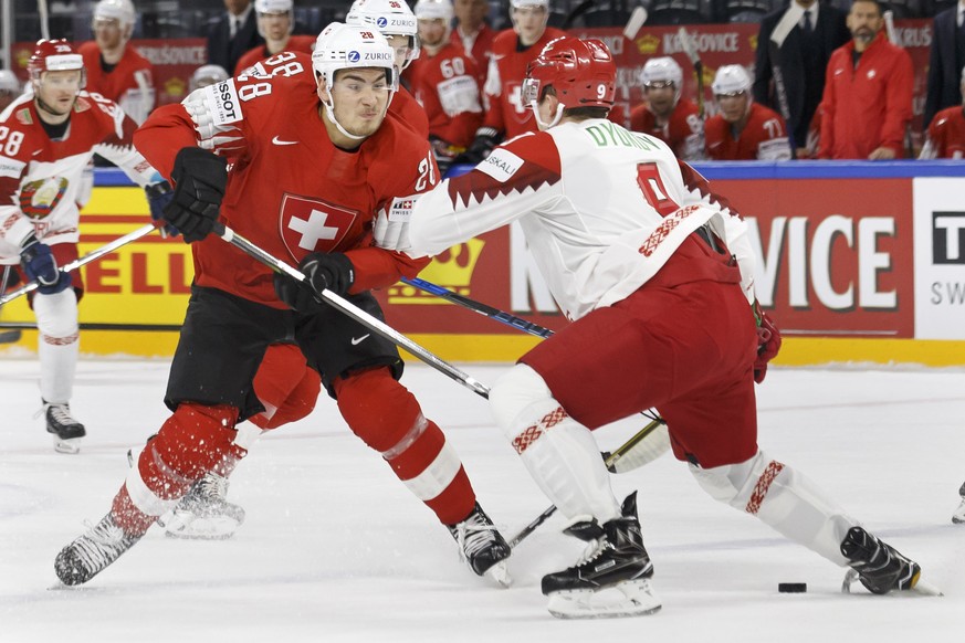 Switzerland&#039;s forward Timo Meier, left, vies for the puck with Belarus&#039; defender Roman Dyukov, right, during the IIHF 2018 World Championship preliminary round game between Switzerland and B ...