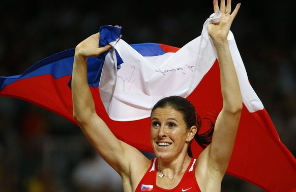 Zuzana Hejnova of the Czech Republic holds her national flag after winning the women&#039;s 400 metres hurdles final at the IAAF World Championships at the National Stadium in Beijing, China August 26 ...