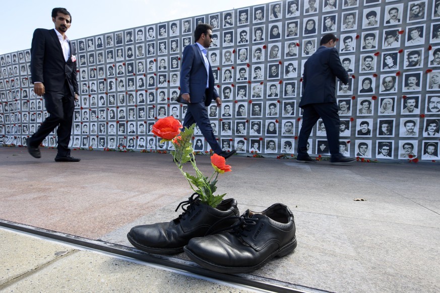 epa06207081 People pass by a wall of photos of victims of the 1988 Massacre of political prisoners in Iran during an exhibition at the Palais des Nations in front of the United Nations (UN) European H ...