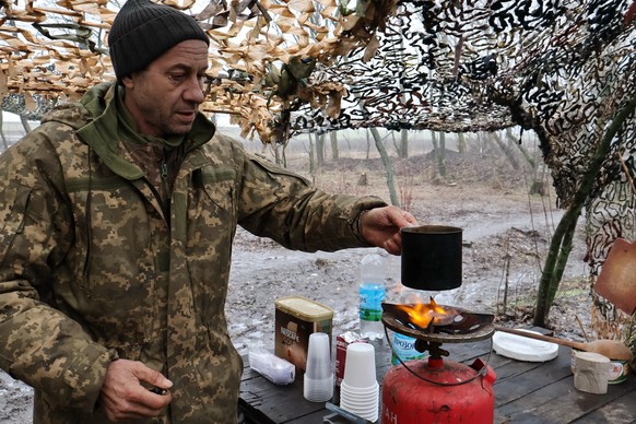 In this photo provided by Ukraine's 65th Mechanized Brigade press service, a soldier prepares tea at their position on the frontline in the Zaporizhzhia region, Ukraine, Saturday, Feb. 7, 2026. ( ...