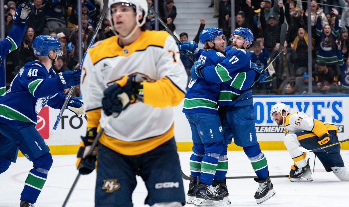 Vancouver Canucks' Filip Hronek (17) celebrates his goal with Brock Boeser (6) as Nashville Predators' Luke Evangelista (77) skates away and Roman Josi (59) watches during the third period o ...