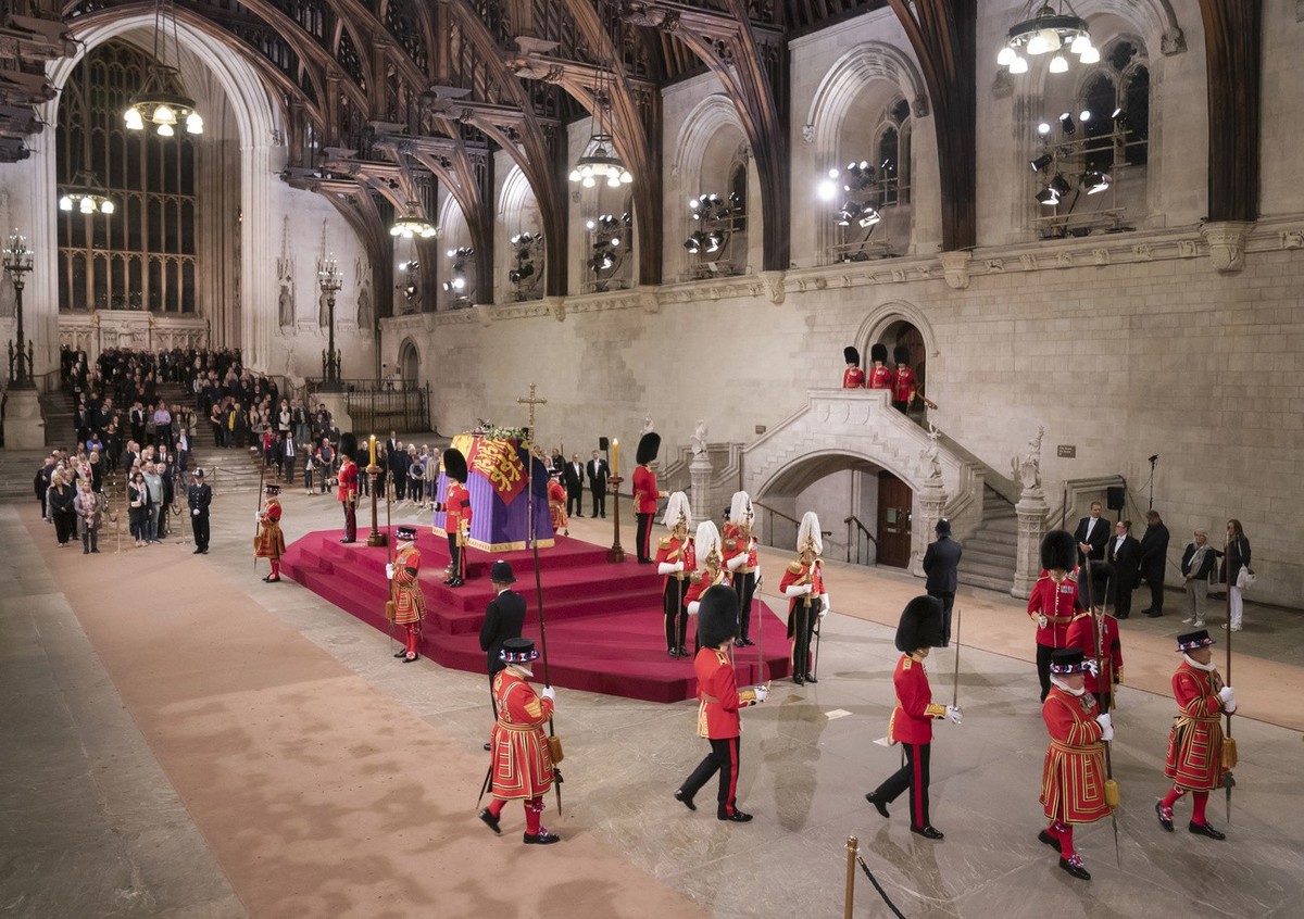 Members of the public file past the coffin of Queen Elizabeth II, draped in the Royal Standard with the Imperial State Crown and the Sovereign's orb and sceptre, lying in state on the catafalque  ...