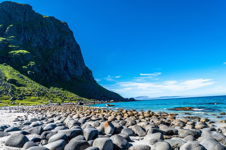 Crystal clear water, fine white sand and rocks rounded by the waves in the heart of the Arctic Circle