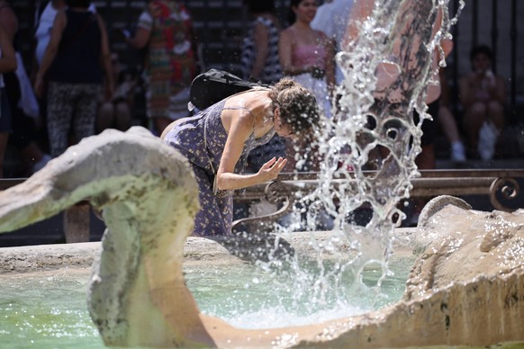 epa10747866 A woman cools off in a fountain during a heat wave in Rome, Italy, 15 July 2023. Italy&#039;s third heatwave of the summer is set to arrive on 16 July, bringing record temperatures. The ne ...