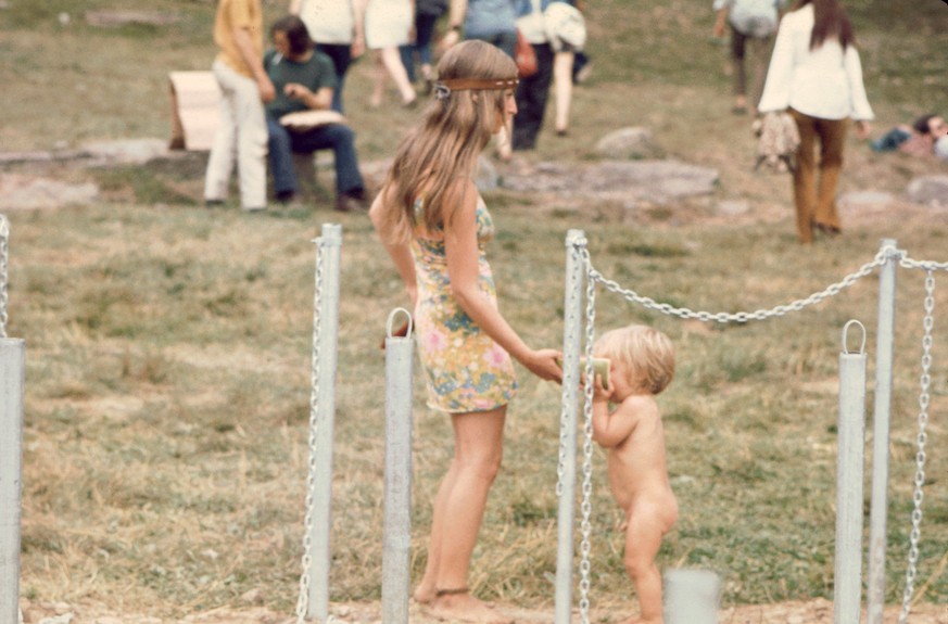 Woman at water pump holds a watermelon for a small child to eat, at the Woodstock music festival, August 1969. (Photo by Ralph Ackerman/Getty Images)