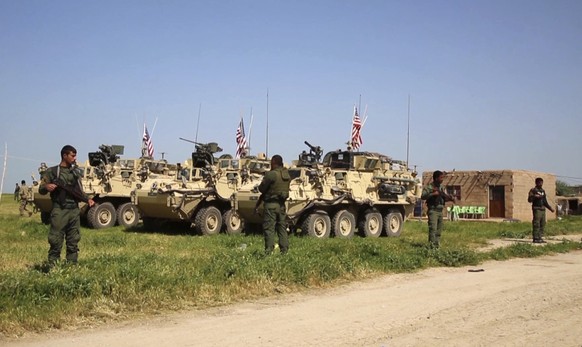 FILE -- In this April, 29, 2017 file image taken from video, shows Kurdish fighters of the People&#039;s Protection Units (YPG) standing guard as U.S. forces take up positions in the northern village  ...