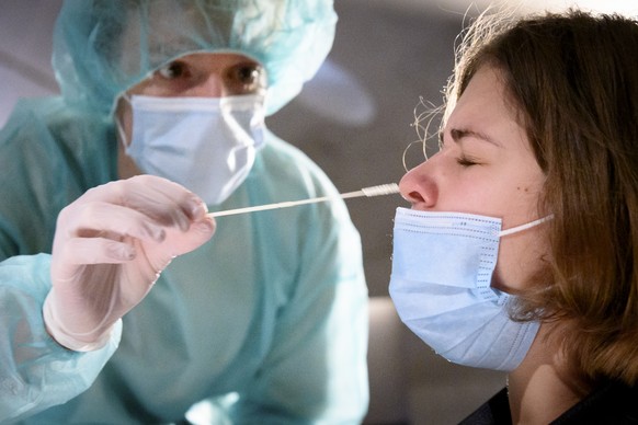 A health worker collects a nose swab sample for a polymerase chain reaction (PCR) test at the Mycorama coronavirus testing facility during the coronavirus disease (COVID-19) outbreak, in Cernier, Swit ...