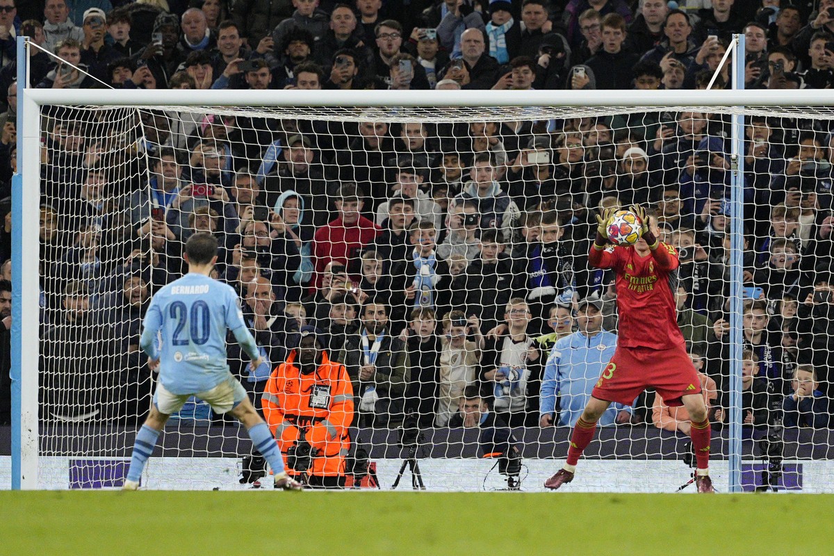 Real Madrid's goalkeeper Andriy Lunin, right, saves a penalty by Manchester City's Bernardo Silva during a shootout during the Champions League quarterfinal second leg soccer match between M ...