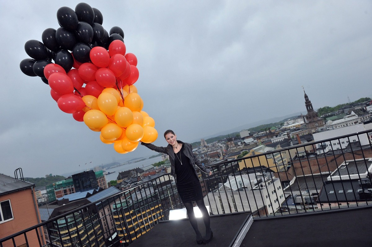 epa02171177 German singer Lena Meyer-Landrut holds some balloons with the colors of the German flag on the roof of a building in the Norwegian capital Oslo, Norway, 24 May 2010. Lena will represent Ge ...