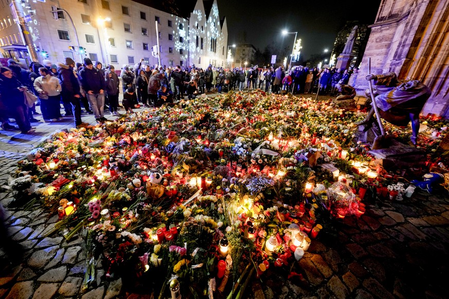 People have laid flowers and candles in front of the Johannis church close to the Christmas market, where a car drove into a crowd on Friday evening, in Magdeburg, Germany, Saturday, Dec. 21, 2024. (A ...