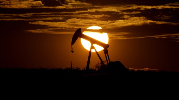 FILE - The sun sets behind an idle pump jack near Karnes City, USA, April 8, 2020. Oil prices surged another $5 per barrel on Wednesday, March 2, 2022, after an agreement by the United States and othe ...