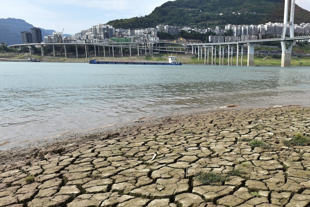 A dried riverbed is exposed after the water level dropped in the Yangtze River in Yunyang county in southwest China's Chongqing Municipality, Tuesday, Aug. 16, 2022. Unusually high temperatures a ...