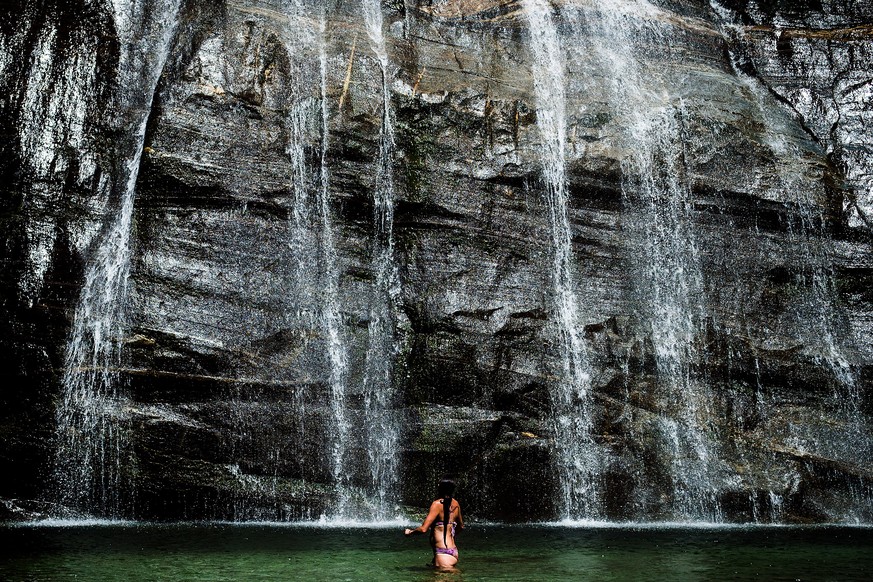 Eine Frau vergnuegt sich im Fluss vor dem Wasserfall "Cascata Grande" in Bignasco, im Maggiatal, am Sonntag, 17. Juli 2016. Das tessiner Maggiatal ("Valle Maggia") ist reich an Was ...