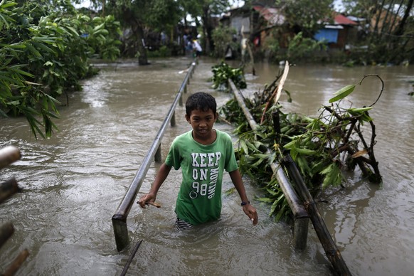 Ein Junge watet durch die Wassermassen: Mindestens fünf Menschen sind durch den Taifun Nock-Ten auf den Philippinen ums Leben gekommen.&nbsp;