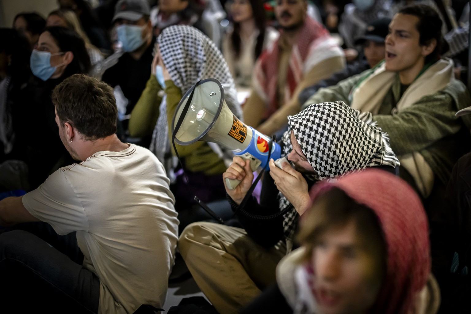 Pro-Palestinian demonstrators shout slogans during a protest in the entrance hall of the main building of the ETH Zurich on Tuesday, May 7, 2024 in Zurich, Switzerland. (KEYSTONE/Michael Buholzer)
