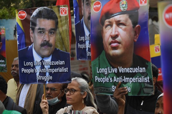 epa12625765 People hold portraits of Venezuelan president Nicolas Maduro and former president Hugo Chavez during a protest against the operation by US forces in Venezuela, in Karachi, Pakistan, 04 Jan ...