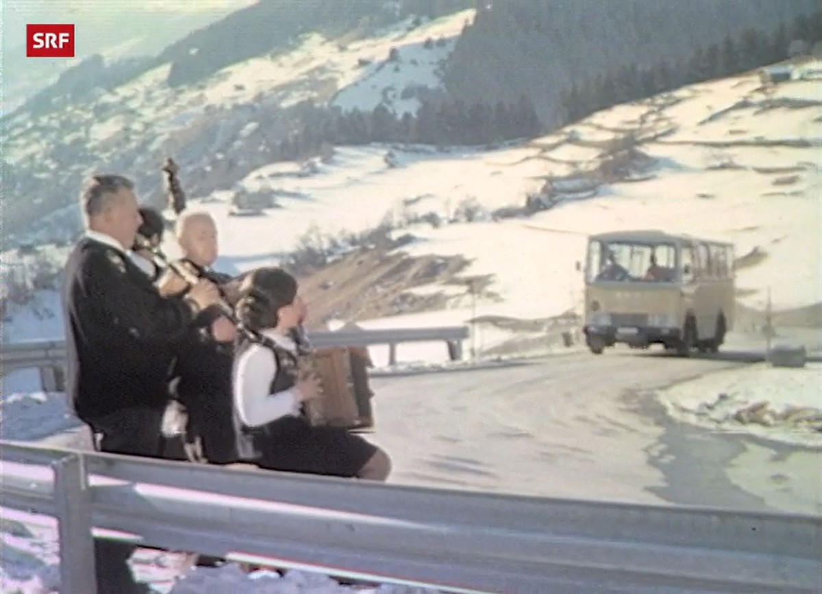 Ausschnitt aus der Sendung Bodeständigi Choscht auf TV DRS vom 2. März 1975, in dem eine Gruppe Ländler spielt, während ein Postauto vorbeifährt. Ein Mal im Monat erfüllte Moderator Wysel Gyr musikali ...