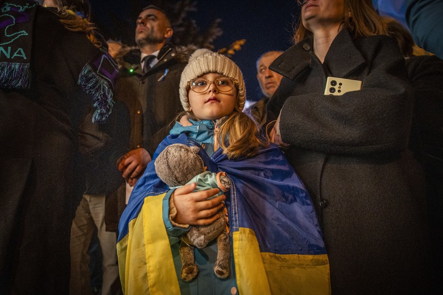 KEYPIX - epa12773854 Little girl with Ukrainian flag listens to speech during the Solidarity March in Bratislava, Slovakia, 24 February 2026. The march commemorates the 4th anniversary of Russian aggr ...