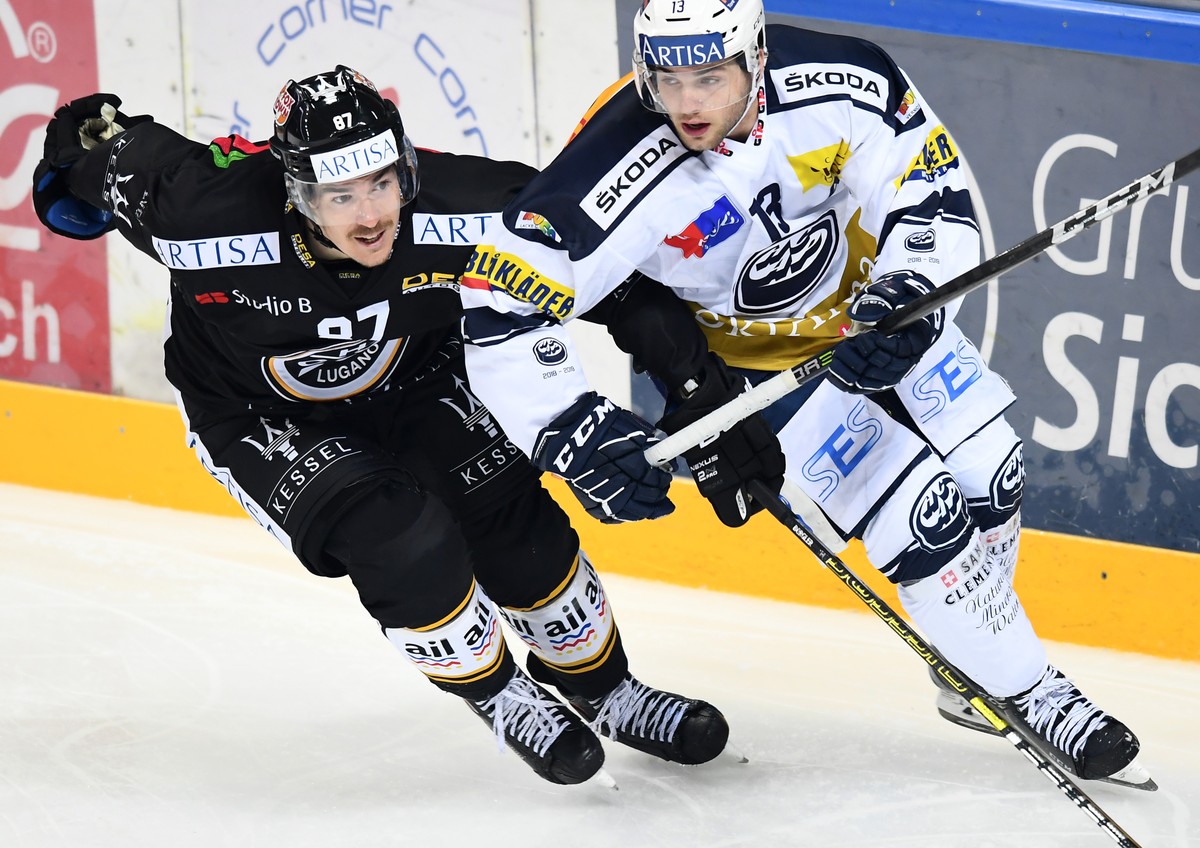 Lugano's player Dario Buergler, left, fights for the puck with Ambri's player Marco Mueller, right, during the preliminary round game of National League Swiss Championship 2018/19 between Sw ...