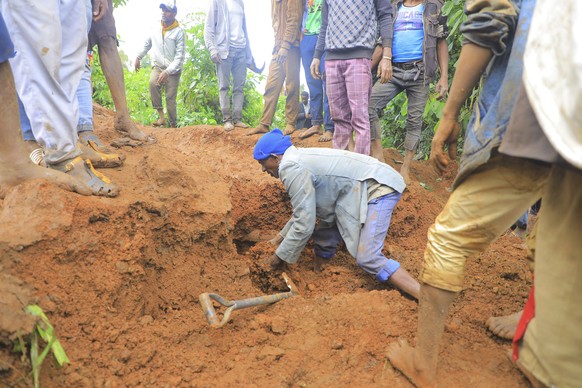 ADDS NAME OF THE PHOTOGRAPHER - In this handout photo released by Gofa Zone Government Communication Affairs Department, a man searches for survivors hundreds of people gather at the site of a mudslid ...