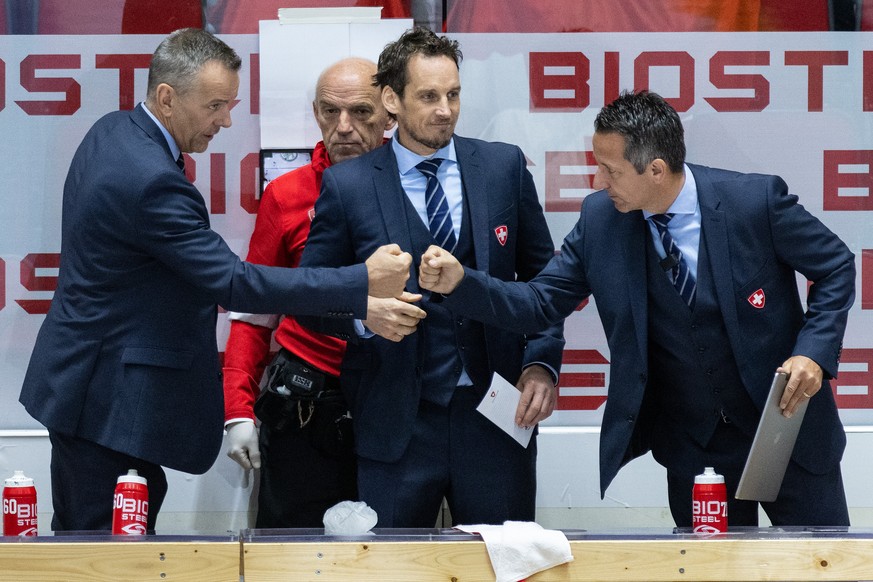 Switzerland&#039;s head coach Patrick Fischer, center, and Tommy Albelin, assistant coach, left, and Marco Bayer, assistant coach, right, celebrate their victory after the Ice Hockey World Championshi ...