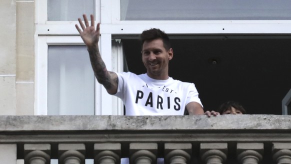 Argentinian soccer star Lionel Messi waves to supporters from his hotel balcony in Paris, Tuesday, Aug. 10, 2021. Lionel Messi finalized agreement on his Paris Saint-Germain contract and arrived in th ...