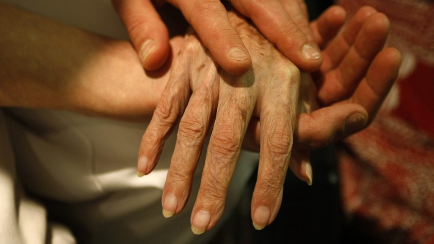 **File** Ein Pfleger massiert am 25. Oktober 2007 in einem Seniorenzentrum in Stuttgart die Hand einer alten Frau. Der Bundesgerichtshof (BGH) hat am Freitag, 25. Juni 2010, ein Grundsatzurteil zur St ...