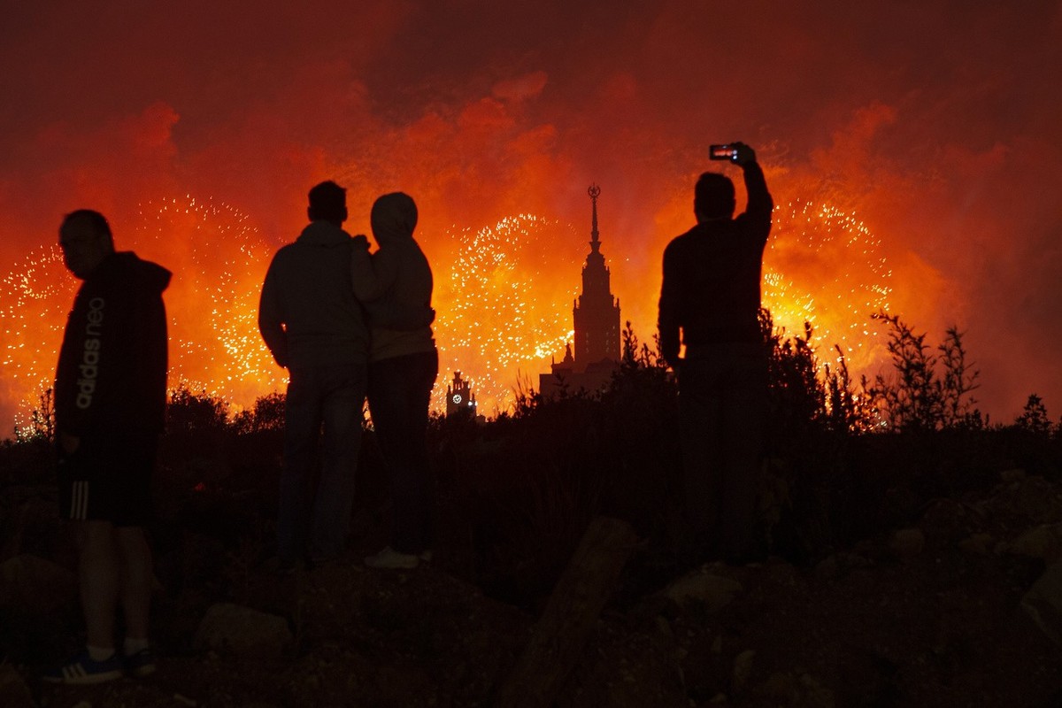 People watch and take pictures of the fireworks exploding over the Moscow's University during the celebration of the 75th anniversary of the Nazi defeat in World War II in Moscow, Russia, on Wedn ...