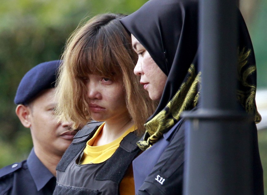 Vietnamese suspect Doan Thi Huong, center, in the ongoing assassination investigation, is escorted by police officers out from Sepang court in Sepang, Malaysia on Wednesday, March 1, 2017. Appearing c ...