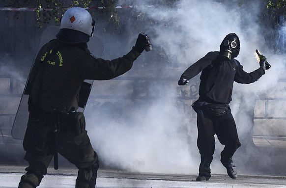 A masked protester throws a molotov cocktail at riot policemen during clashes outside the University of Thessaloniki campus, in Thessaloniki, Greece Saturday March 10, 2018. Anarchists have clashed wi ...