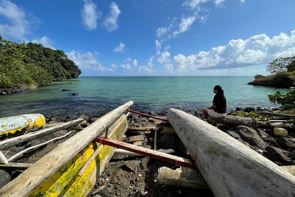Eseta Vusamu sits near the water Thursday, Sept. 29, 2022, in the village of Faleasiu on the island of Upolu in Samoa. When and if an island nation fully submerges due to climate change, what happens  ...