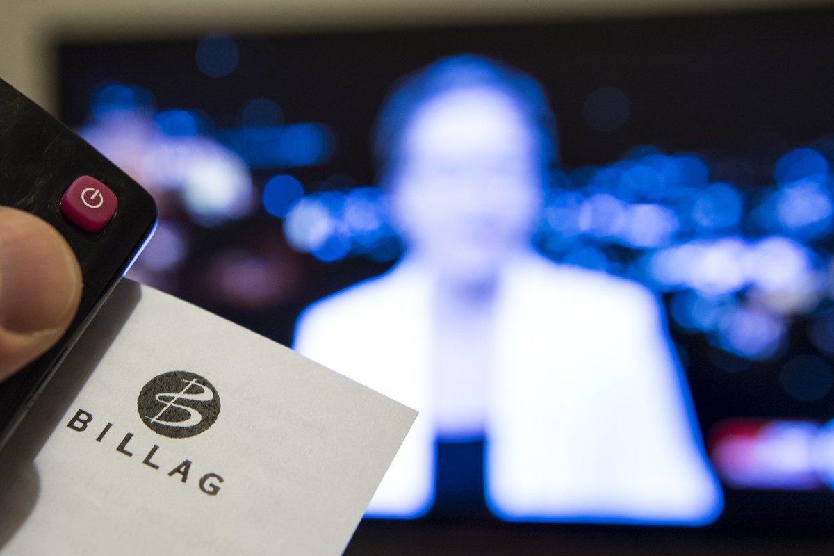 ARCHIVBILD ZUR SENKUNG DER BILLAG-STEUER DURCH DEN BUNDESRAT AM MITTWOCH, 18. OKTOBER 2017 - Une personne tient dans sa main une telecommande ainsi qu'un document de l'entreprise responsable ...