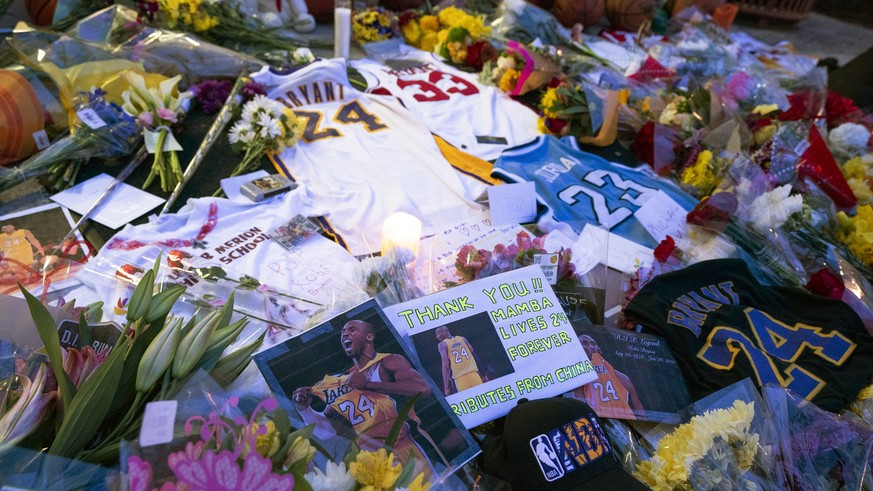 Flowers, jerseys and imagery is left in remembrance to Kobe Bryant at a small memorial at the entrance of the Bryant Gymnasium at Lower Merion High School, Monday, Jan. 27, 2020, in Wynnewood, Pa. The ...