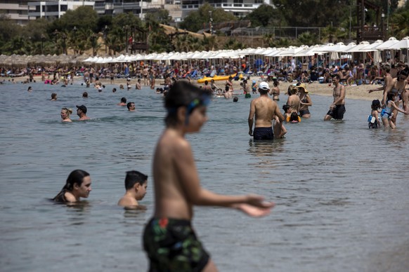 Swimmers enjoy the sea at Alimos beach, near Athens, on Saturday, May 16, 2020. Greece allowed the reopening of organized beaches, where visitors pay to get in, from Saturday when a heat wave is expected to hit the country, a measure that would affect 515 beaches all over Greece, where shade umbrellas must be planted at least 4 meters (13 feet) apart, and a maximum 40 people will be allowed in every 1,000 square meters (11,000 square feet) of beach. (AP Photo/Yorgos Karahalis)