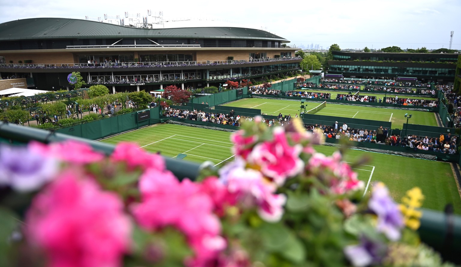 epa10040800 General view of court No.1 (L) as matches are temporarily suspended due to rain on the third day at the Wimbledon Championships in Wimbledon, Britain, 29 June 2022. EPA/NEIL HALL EDITORIAL ...