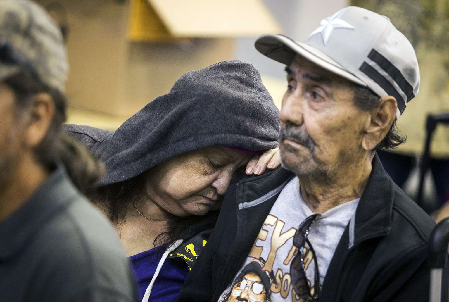 Guadalupe Guerra rests her head on the shoulder of her husband, Ray, while waiting to board a bus headed for San Antonio at an evacuation center in Corpus Christi, Texas on Friday, Aug. 25, 2017. Hund ...